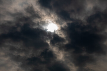 defocused the dark cloudy sky with gaps shining from the sun's light in the middle