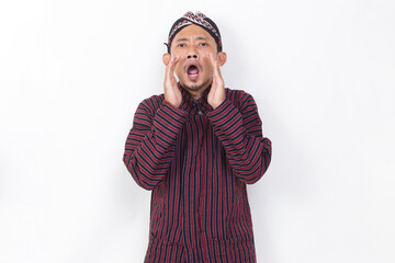 Fototapeta premium asian man with javanese traditional cloth lurik shouting and yelling announcing isolated on white background