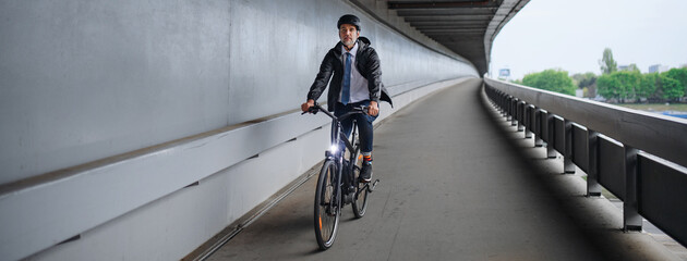 Fototapeta na wymiar Businessman commuter on the way to work, riding bike over bridge, sustainable lifestyle concept.