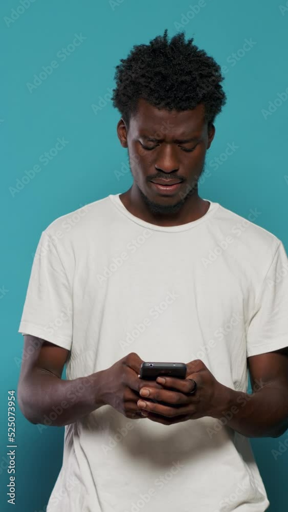 Wall mural confused man using smartphone for text messages and browsing internet. portrait of modern person loo