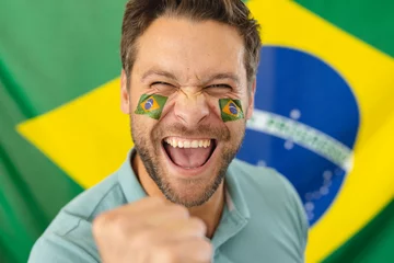 Fotobehang Image of happy caucasian man with flags of brazil on face over flag of brazil © wavebreak3