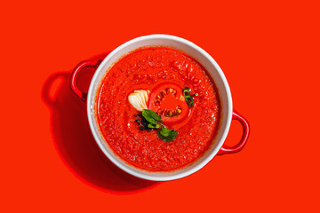 Spicy tomato soup. Healthy vegan hot dish, croutons, vintage cutlery. Bright red background