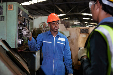 male african foreman training and teaching how to use machine control with workers in factory