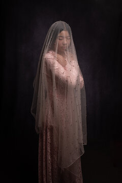 classic fine art studio portrait of girl in dress with veil in dark painterly style