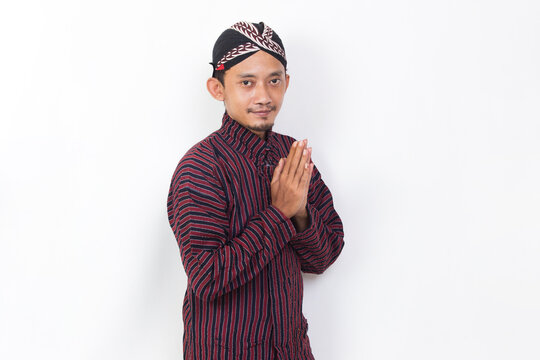 asian man with javanese traditional cloth lurik welcoming guests gretting isolated on white background