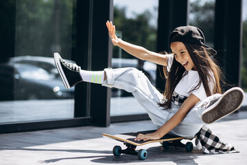 Cute school girl with skate board in the street