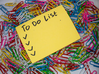 selective focus Yellow Sticky note with to do list and checklist written on it with colorful...