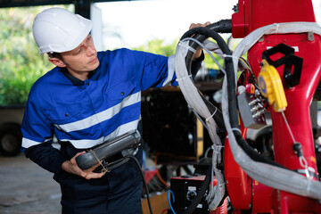 factory worker or engineer operating remote switch controller to control robot machine in the factory