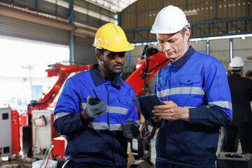 factory workers or engineer using tablet for work in robot factory