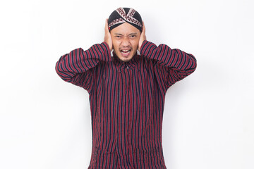 asian man with javanese traditional cloth lurik covering both ears with hands isolated on white background