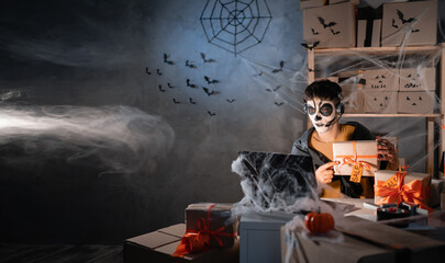 Arab man business owner wears white clay skull, professional makeup in home office. accepts an order on the site writes the address on the box. Festive decorated office. halloween sale concept.