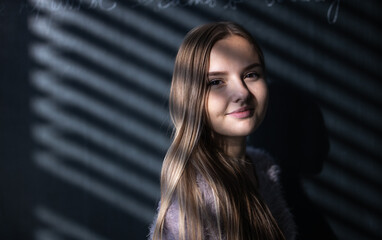 Pretty, young female student in front of a blackboard during class