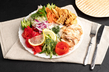 Shawarma on a plate, a large portion of shawarma on a plate, side view, black background