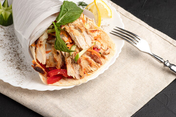Shawarma with chicken, large portion of shawarma with chicken, side view, black background