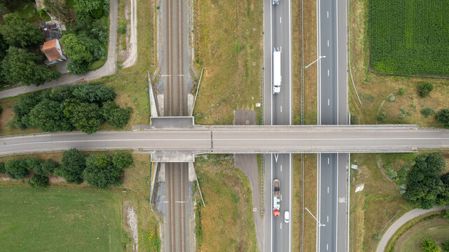 Aerial view of highway road junction. Highways, railroads, , bridge and green fields on the outskirts of the city. in Belgium Transport concept. High quality photo shot by a drone
