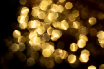 Obraz premium Golden blurred bokeh lights on black background. Glitter sparkle stars for celebrate. Overlay for your design