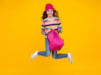 Fototapeta na wymiar Autumn school. Teenager school girl with backpack in autumn clothes on yellow isolated studio background. Happy teenager, positive and smiling emotions of teen girl