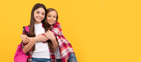 School girls friends. concept of education. kids with long hair on yellow background. Banner of schoolgirl student. School child pupil portrait with copy space.