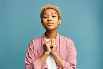 Sad african american millennial girl standing on blue background begging god to forgive her, asking...