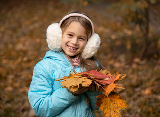 portrait of beautiful girl with long blonde hair staying near tree  in autumn park