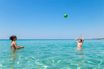 Happy teenagers  playing volleyball in water at the beach.Traveling, vacation and fun