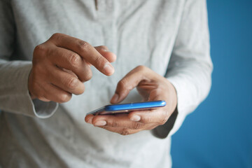 Close up of young man hand using smart phone.