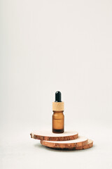 Obraz na płótnie Canvas Amber glass dropper bottle on a wooden podium