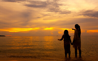 Fototapeta premium Women and children traveling to the sea during the high season invite each other to look at the yellow sky.