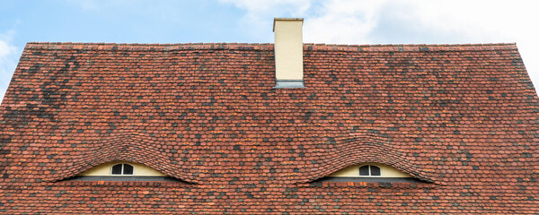 Old beautiful european german fachwerk building rooftop with eye shaped windows and chimney....