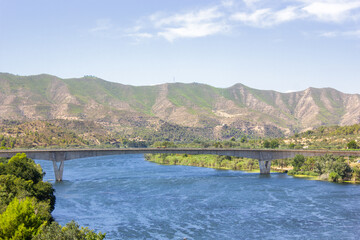 Fototapeta na wymiar Bridge across the Ebro River, with the ebro river and the mountains in the background