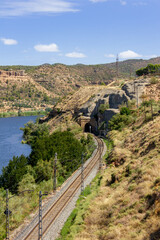 Railroad lines with tunnel, river and mountains