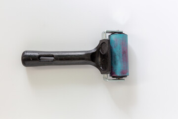 Small rubber brayers with black hand held use in craft process on white background in top view.