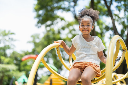 Portrait of happy African American little girl smiling look at camera at playground in the park