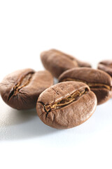 Roasted coffee beans isolated close up on white background, clipping path