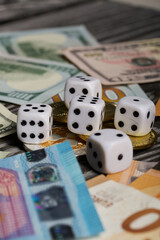 Dice among dollar and euro banknotes. Cryptocurrency coins. Multicurrency savings. Risk while saving money.