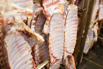 fresh pork carcasses hanging on hooks at a meat processing plant close-up
