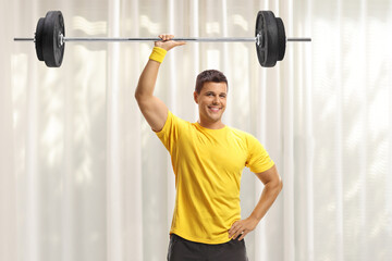 Young fit man lifting weigths at home