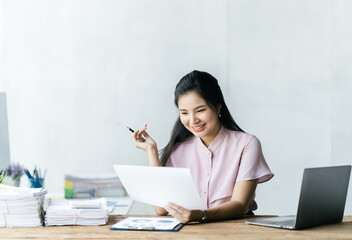 Asian woman working with laptop in her office. business financial concept.