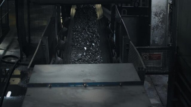 The ore moves along the factory line. Ore processing facility. Ore mining. Production. 4K. Shooting inside the factory. 4К