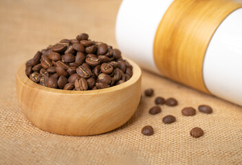 Coffee beans in wooden bowl put on the sackcloth.