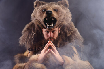 A traditional medieval bearded man dressed as an animal-bear, a symbol of power, strength and...
