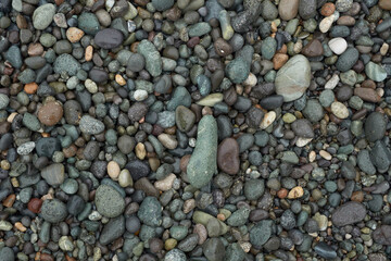 Pebble beach stones background, natural rounded gravel on the seashore nature background texture pattern