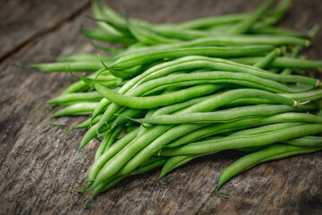 Bunch of organically grown 'Maxibel' French filet green beans harvested from a home garden on a rustic wooden table