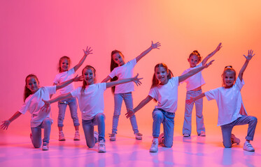 Group of children, school age girls in sportive casual style clothes dancing in choreography class...