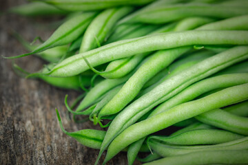 Bunch of organically grown 'Maxibel' French filet green beans harvested from a home garden on a rustic wooden table