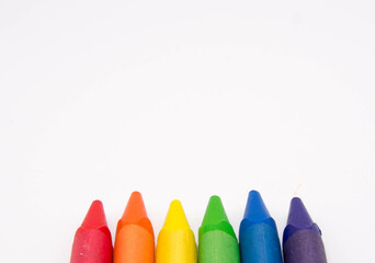 Group of colored pencils and crayons on white background. Text space.