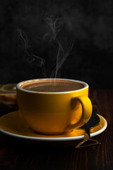 hot latte in yellow glass on wooden table