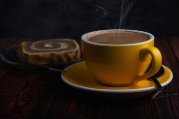 hot latte in yellow glass on wooden table