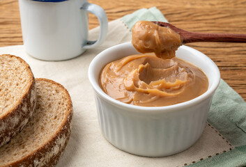 Doce de leite, traditional brazilian creamy milk sweet over wooden table