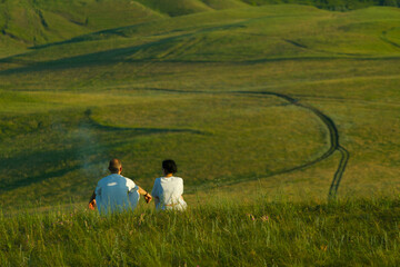 Fototapeta na wymiar Couple sit on the grass